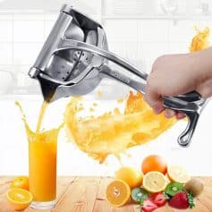 Bright orange juice pouring from a stainless steel juicer into a glass, with fresh oranges, lemons, strawberries, and kiwis on a wooden table, emphasizing healthy lifestyle and fresh ingredient use.