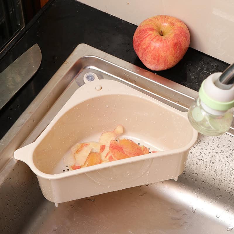 Fresh apple slices washed in a white colander under running water for food preparation.