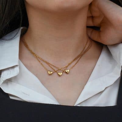 Delicate layered gold necklaces with personalized initial and heart charms, perfect for everyday wear or gift giving, showcasing stylish and quality jewelry.