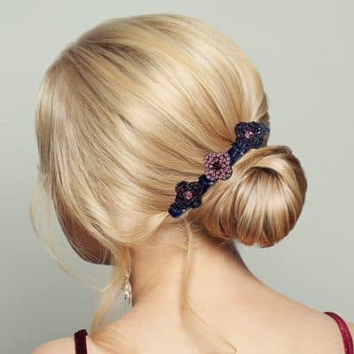 Blonde hair styled in a smooth, elegant bun secured with a decorative floral hair clip at Monalisa Store. Perfect for special occasions or daily style enhancements.