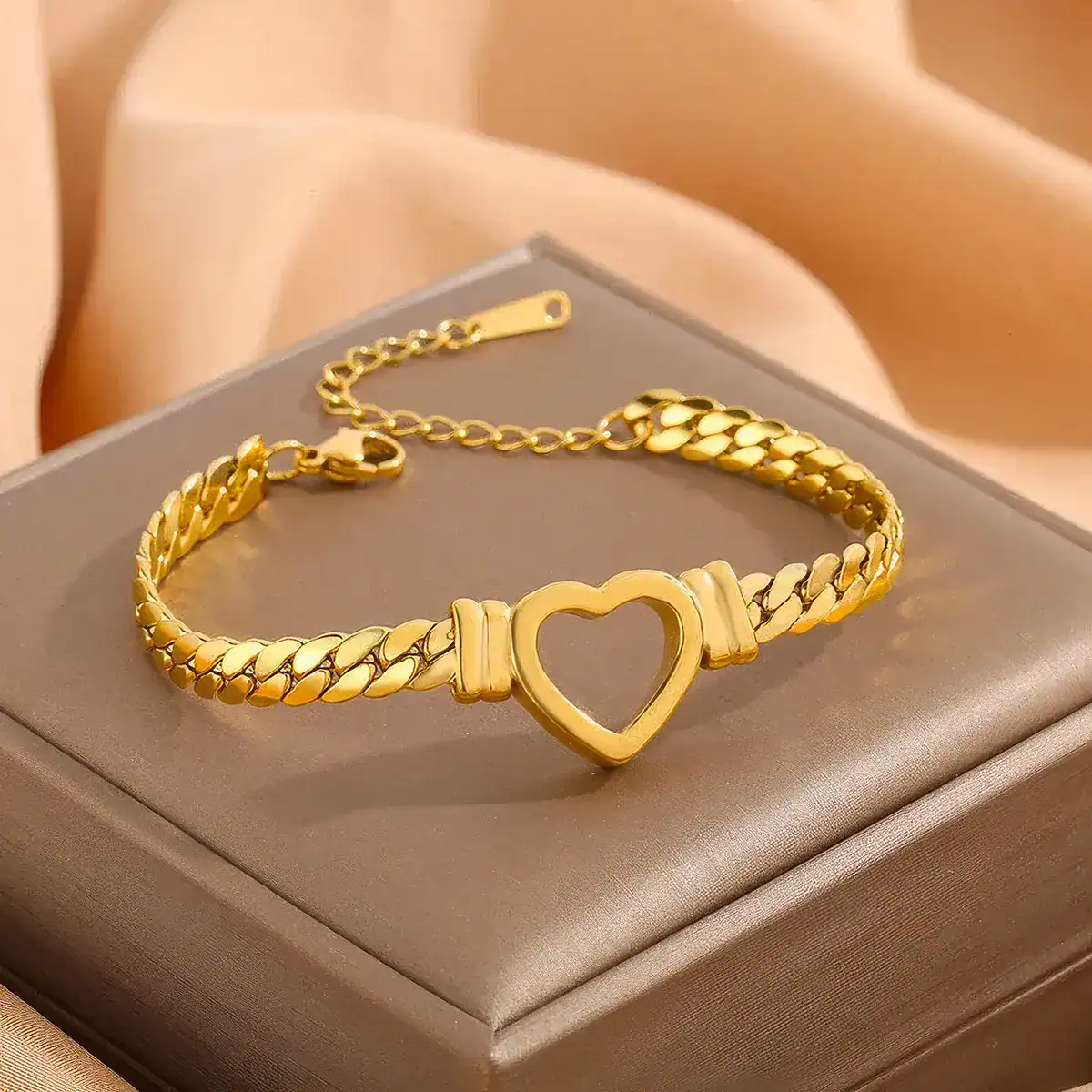 Elegant gold bracelet featuring a heart-shaped centerpiece with a stylish chain design, perfect for women's jewelry collections and special occasions.