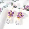 Luxurious gold earrings with purple gemstones and crystal drops, perfect for sophisticated jewelry collection.