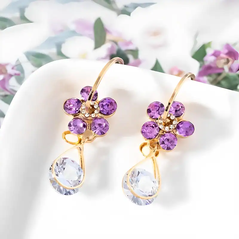 Luxurious gold earrings with purple gemstones and crystal drops, perfect for sophisticated jewelry collection.