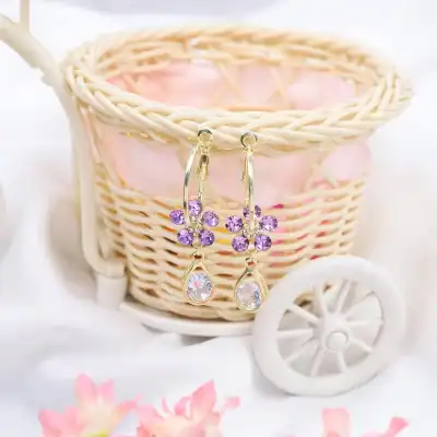 Beautiful gold earrings with purple stones and teardrop crystals, perfect for stylish occasions and enhancing your jewelry collection.