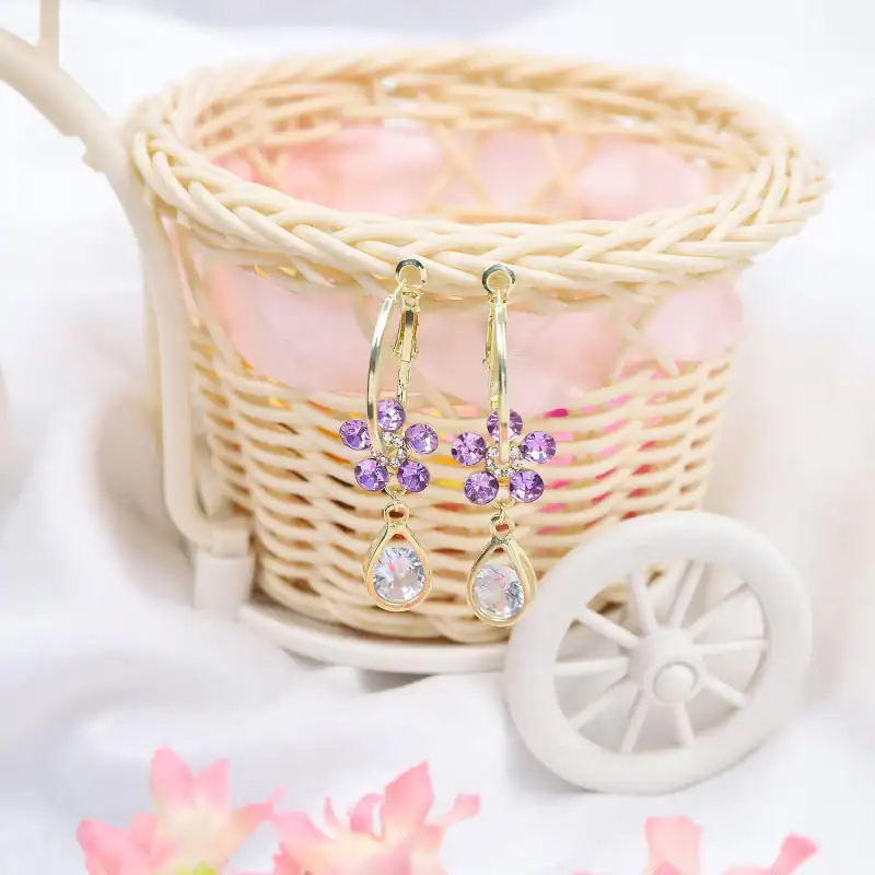 Beautiful gold earrings with purple stones and teardrop crystals, perfect for stylish occasions and enhancing your jewelry collection.