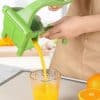 Citrus juicer extracting fresh orange juice with vibrant green juicer in a modern kitchen setting. Perfect for healthy lifestyle and nutritious breakfast preparation.