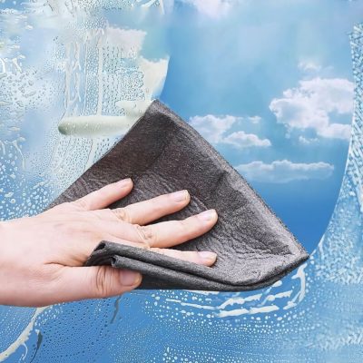Cleaning a car windshield with a microfiber cloth in a professional setting for better visibility and safety.