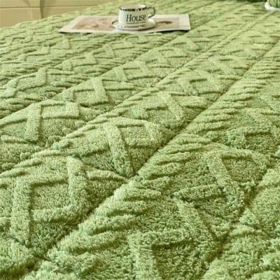 Luxurious green textured rug with intricate geometric pattern, perfect for living room or bedroom decor. Durable and soft, enhances the cozy ambiance of your home.
