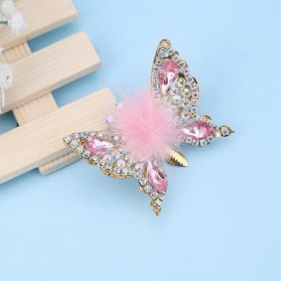 Elegant butterfly brooch with pink crystals and faux feathers, perfect for accessories and gifts.