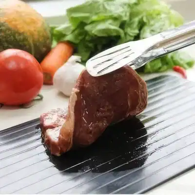 ALT text: Juicy cooked steak on a grill with fresh vegetables including tomato, carrot, garlic, broccoli, and lettuce, perfect for healthy eating and meal preparation.