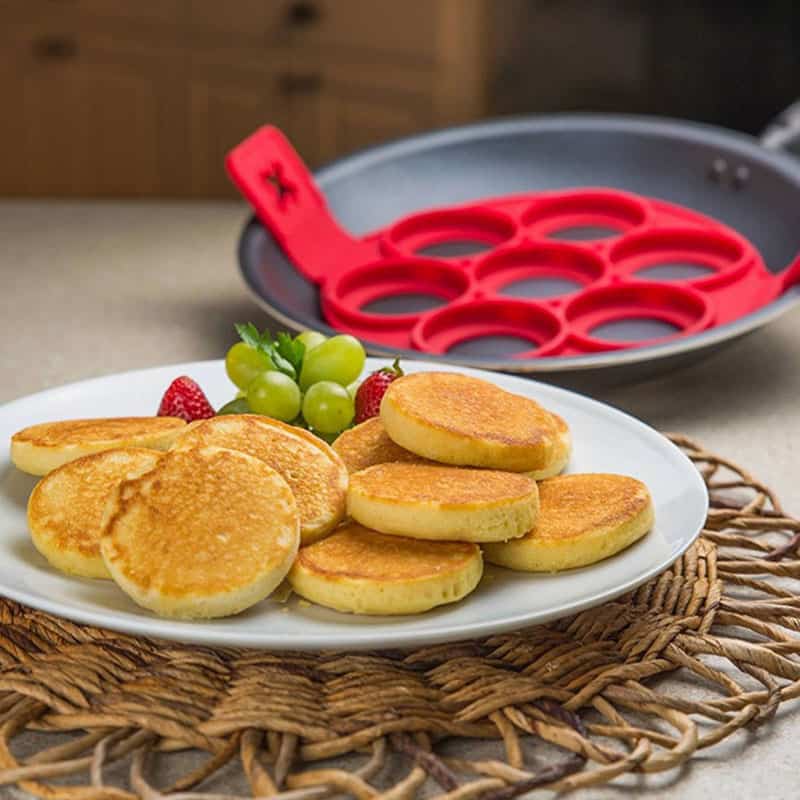 Delicious homemade pancakes served with fresh grapes and strawberries, perfect for a hearty breakfast or brunch. A delightful plate showcasing comfort food with a touch of elegance.