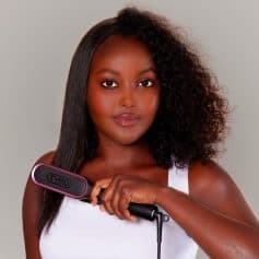 A woman with smooth, shiny hair using a Tymo hair straightening brush, emphasizing professional hair styling tools available at Monalisa Store.