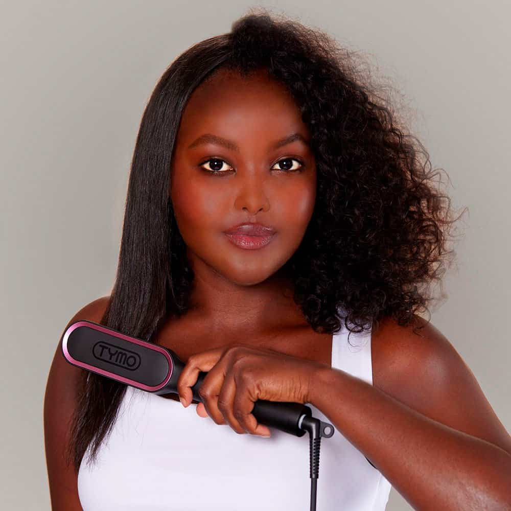 A woman with smooth, shiny hair using a Tymo hair straightening brush, emphasizing professional hair styling tools available at Monalisa Store.