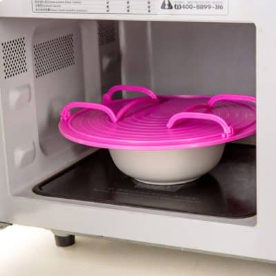 A pink microwave sterilizer tray inside a microwave oven used for sterilizing medical tools, emphasizing hygiene and safety. Perfect for medical professionals and clinics seeking efficient sterilization solutions.