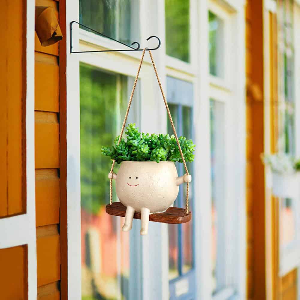 Adorable smiling plant pot hanging on porch with lush green plant for home garden decor. Perfect for enhancing your indoor or outdoor space.