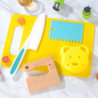 Child-safe knife and fun cutting board set for kids, perfect for safe cooking and food play. Bright colors and playful designs make cooking fun for children learning kitchen skills.