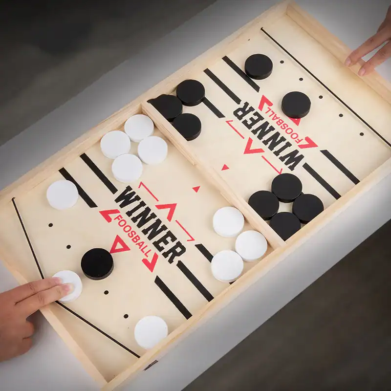 Hockey table game with black and white caps, perfect for family fun and recreational activities. Durable wooden frame with clear markings, suitable for all ages.