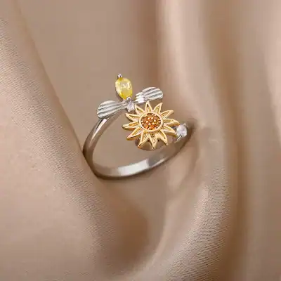 Dainty silver and gold ring with sunflower design and yellow gemstone accents, perfect for stylish jewelry lovers.