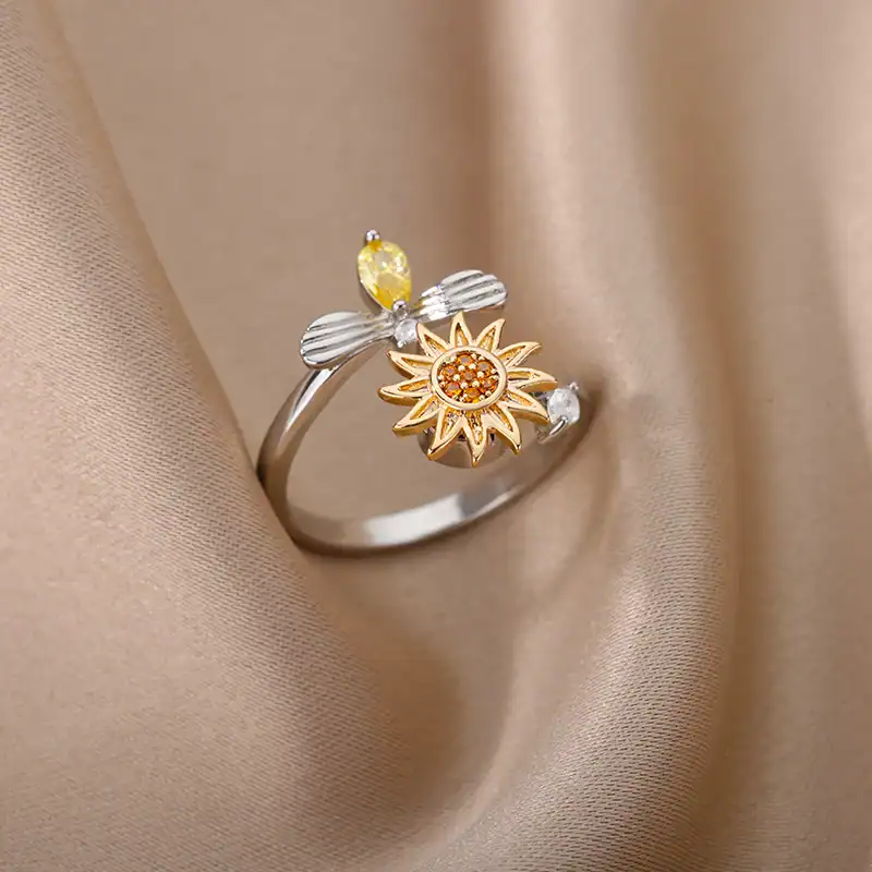 Dainty silver and gold ring with sunflower design and yellow gemstone accents, perfect for stylish jewelry lovers.