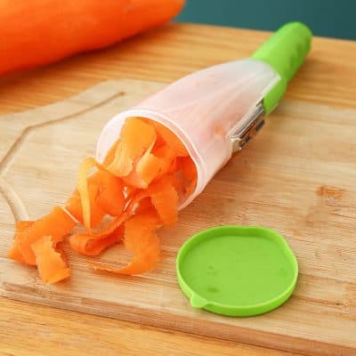 A close-up of a carrot grating tool with freshly grated carrot, emphasizing healthy eating and kitchen gadgets for vegetable prep.
