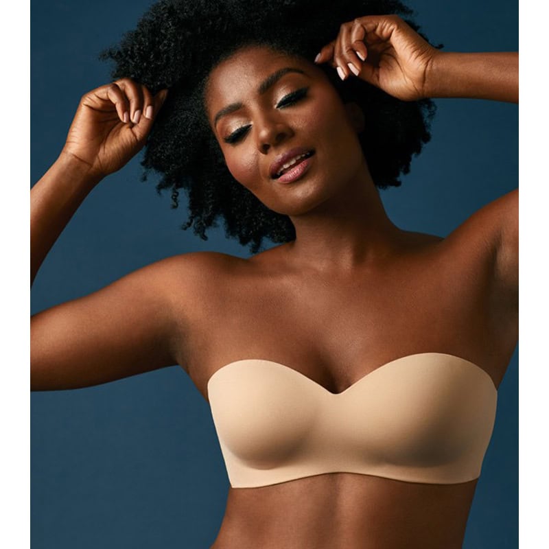 A stunning portrait of a confident Black woman with natural afro hair, wearing a nude strapless bra from Monalisa Store. Emphasizing beauty, comfort, and style in women's lingerie and optical products.