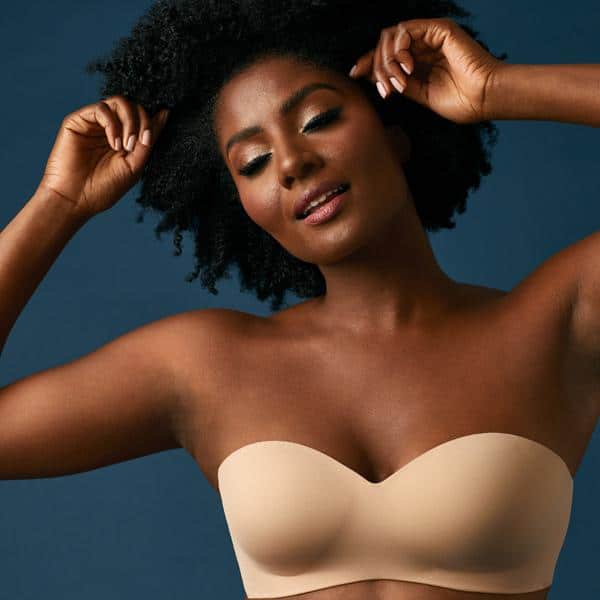 Elegant woman modeling seamless beige strapless bra, showcasing comfort and style, perfect for everyday wear or special occasions.