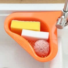 Alt text: Image of cleaning sponges and a mesh scrubber in an orange sink, suitable for optical stores or eyewear cleaning stations.