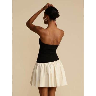 Elegant woman with fashionable black strapless top and white skirt, showcasing a chic look suitable for stylish eyewear choices at Monalisa Store.