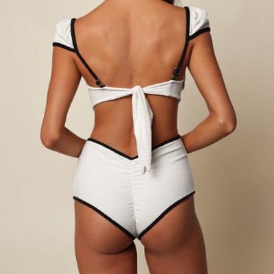 High-quality white bikini with black trim, featuring adjustable ties at the back and shoulders, designed for a stylish and comfortable swimwear experience.