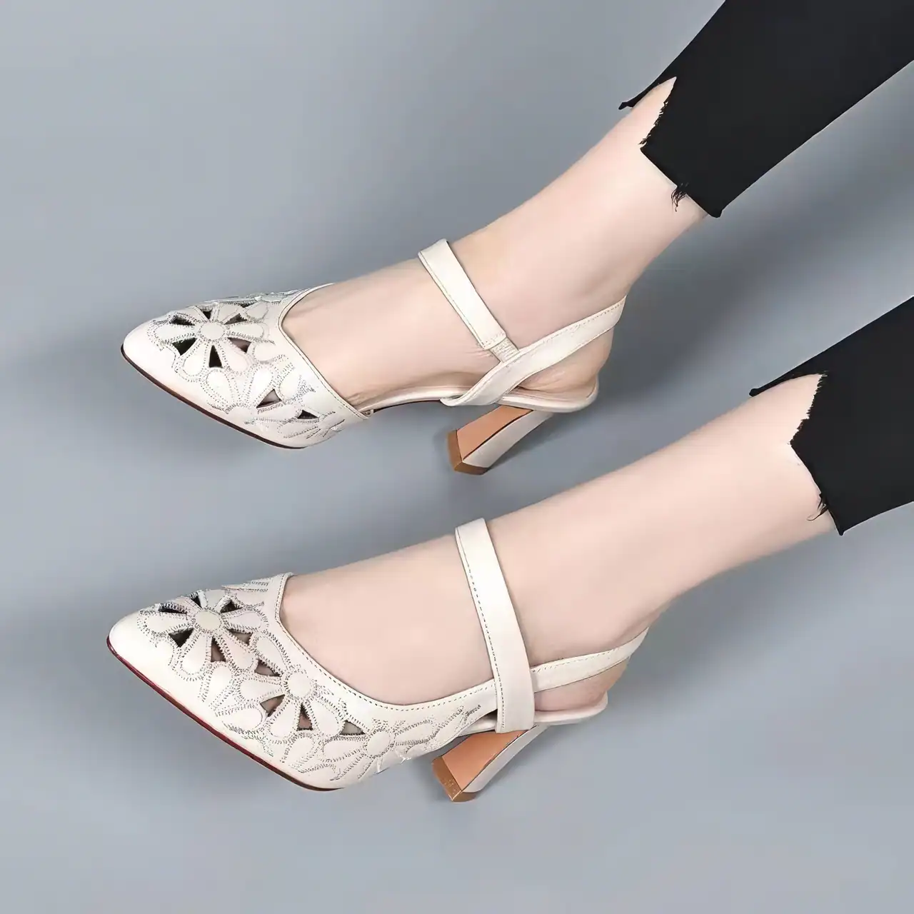 Stylish cream-colored women's shoes with floral cut-out design, ankle tie straps, and block heels, perfect for fashionable and comfortable footwear.