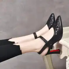 Elegant black laser-cut high heels with ankle strap, perfect for stylish occasions and fashion enthusiasts.