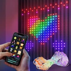 A person using a smartphone app to control vibrant LED heart-shaped wall lights, featuring a remote interface with pixel art icons for customizable lighting decoration.