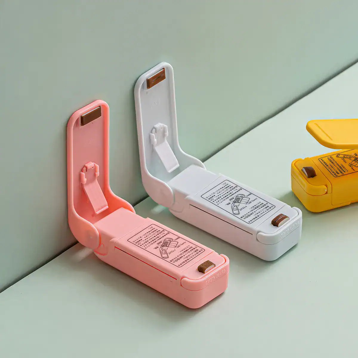 Colorful wall cable organizers in pink, white, and yellow for convenient, clutter-free cable management and enhanced workspace organization.