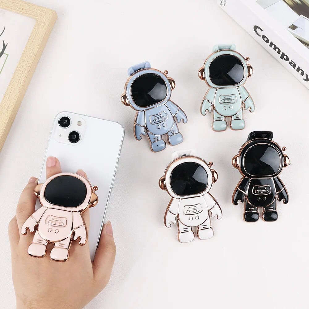 Adorable astronaut phone holder with a large black screen face, designed to attach securely to smartphones, making it easy to carry around and use hands-free.