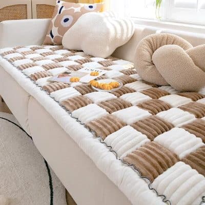 Soft, plush bed throw with neutral beige and white tones, perfect for adding warmth and style to your bedroom decor.