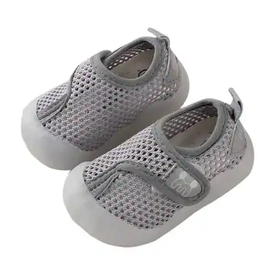 Gray mesh barefoot shoes for babies, lightweight and breathable with soft soles, perfect for early walking. Features easy slip-on design and comfortable fit for infants.