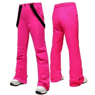 Bright pink ski pants for women with black adjustable straps, insulated for winter sports, and designed for comfort and durability on snowy slopes.