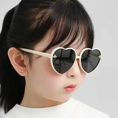 Stylish heart-shaped sunglasses for women, trendy and fashionable, perfect for summer and outdoor activities, featuring dark lenses and cute gold bee accents on the frames.