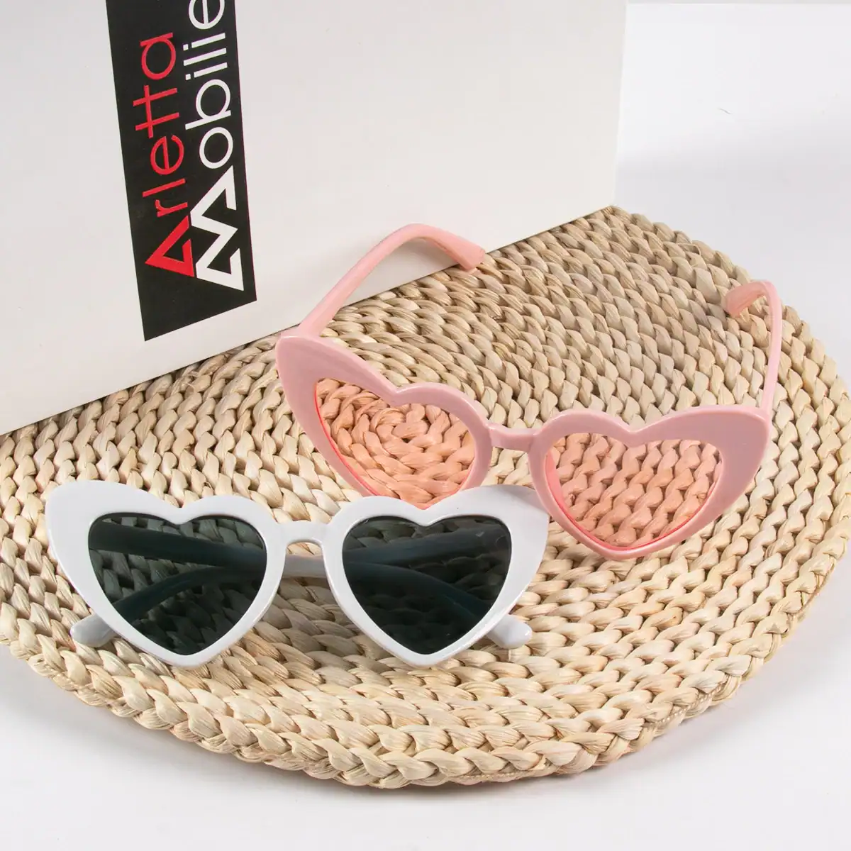 Colorful children’s heart-shaped sunglasses with UV protection, perfect for kids' sunny days, boating, or outdoor activities, featuring pink and white frames with dark lenses.