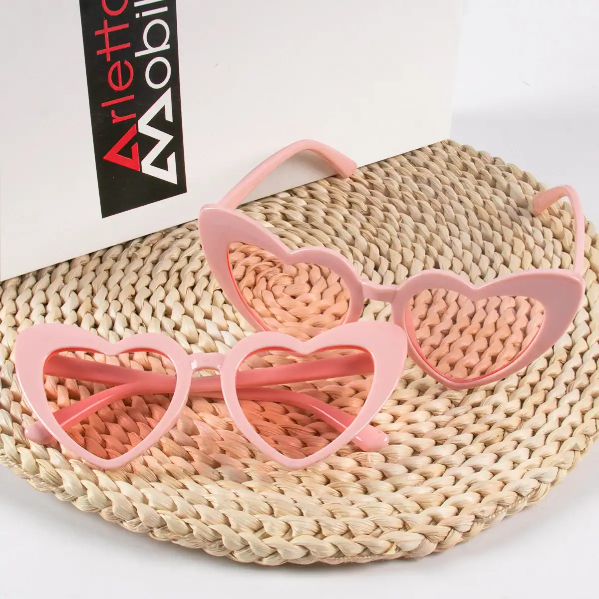 Pink heart-shaped sunglasses with wide lenses, fashionable women's eyewear offering UV protection, ideal for summer outings, beach days, and stylish accessories.