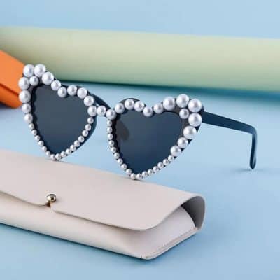 Pearl frame heart-shaped sunglasses with dark lenses, stylish and trendy, perfect for fashion-forward individuals seeking unique optical accessories.