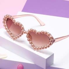 Stylish pearl-embellished sunglasses with pink tinted lenses, perfect for fashion-forward individuals seeking trendy accessories.
