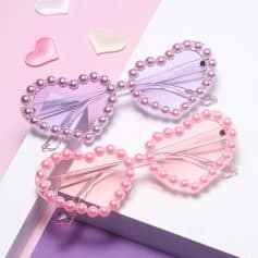 Pink and purple pearl heart-shaped sunglasses with clear frames, fashionable and fun accessories for women, ideal for summer fashion, parties, and stylish casual outings.