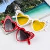 Stylish heart-shaped sunglasses with rhinestones, perfect for beachwear and summer fashion. Available in vibrant red and chic white with tinted lenses for trendy eye protection.