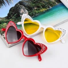 Stylish heart-shaped sunglasses with rhinestones, perfect for beachwear and summer fashion. Available in vibrant red and chic white with tinted lenses for trendy eye protection.