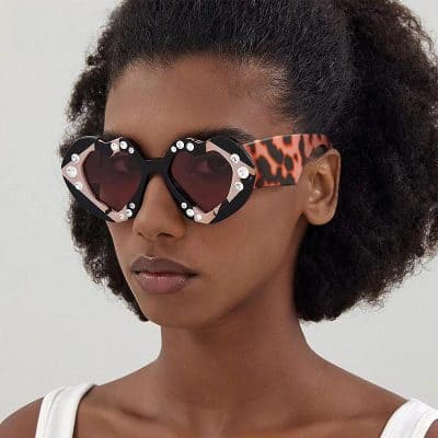 Stylish heart-shaped sunglasses featuring rhinestones, leopard print arms, perfect for fashion-forward eyewear enthusiasts. Elevate your look with trendy, glamorous sunglasses from Monalisa Store.