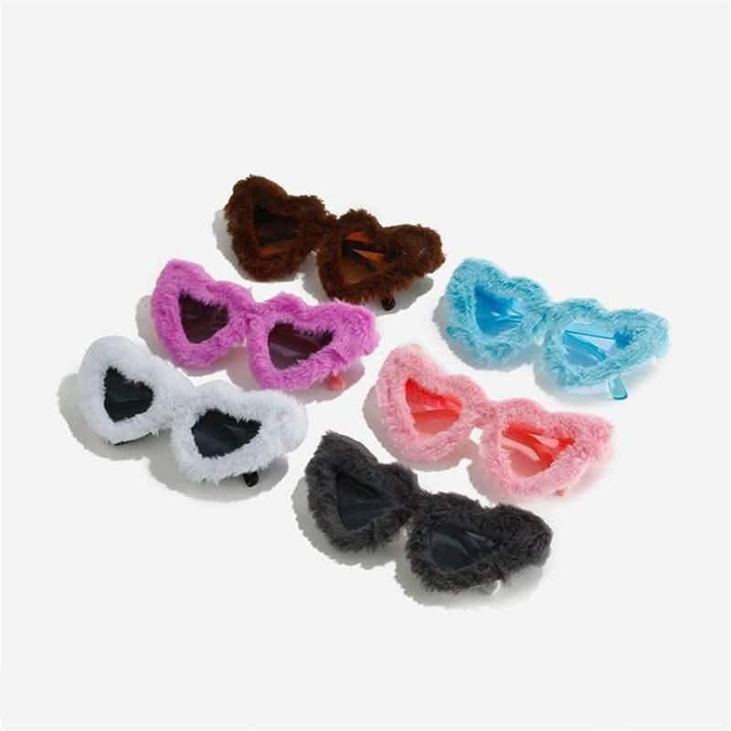 Fuzzy colorful kid’s sunglasses in pink, blue, white, black, brown, and peach, perfect for playful fashion and sun protection. Soft plush material with cartoonish style, ideal for children.
