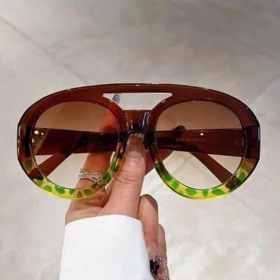 Stylish oversized sunglasses with brown gradient lenses and vibrant green accents, perfect for sun protection and fashion statements.