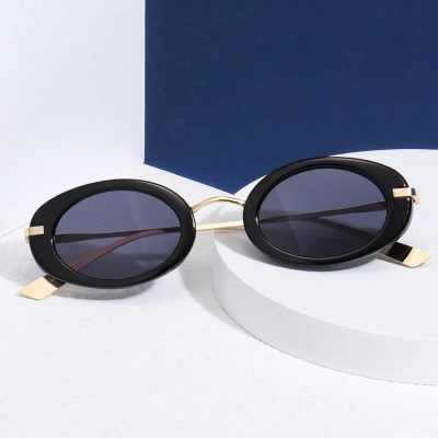 Stylish black oval sunglasses with dark tinted lenses, gold accents, and trendy design, perfect for fashion-forward eyewear lovers.