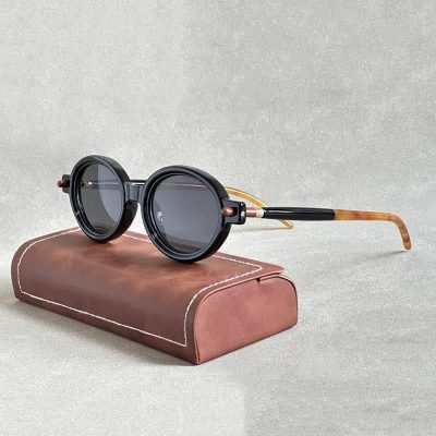 Stylish black round sunglasses with tinted lenses, perfect for sun protection and trendy looks. Includes a brown leather case for safekeeping and portability.